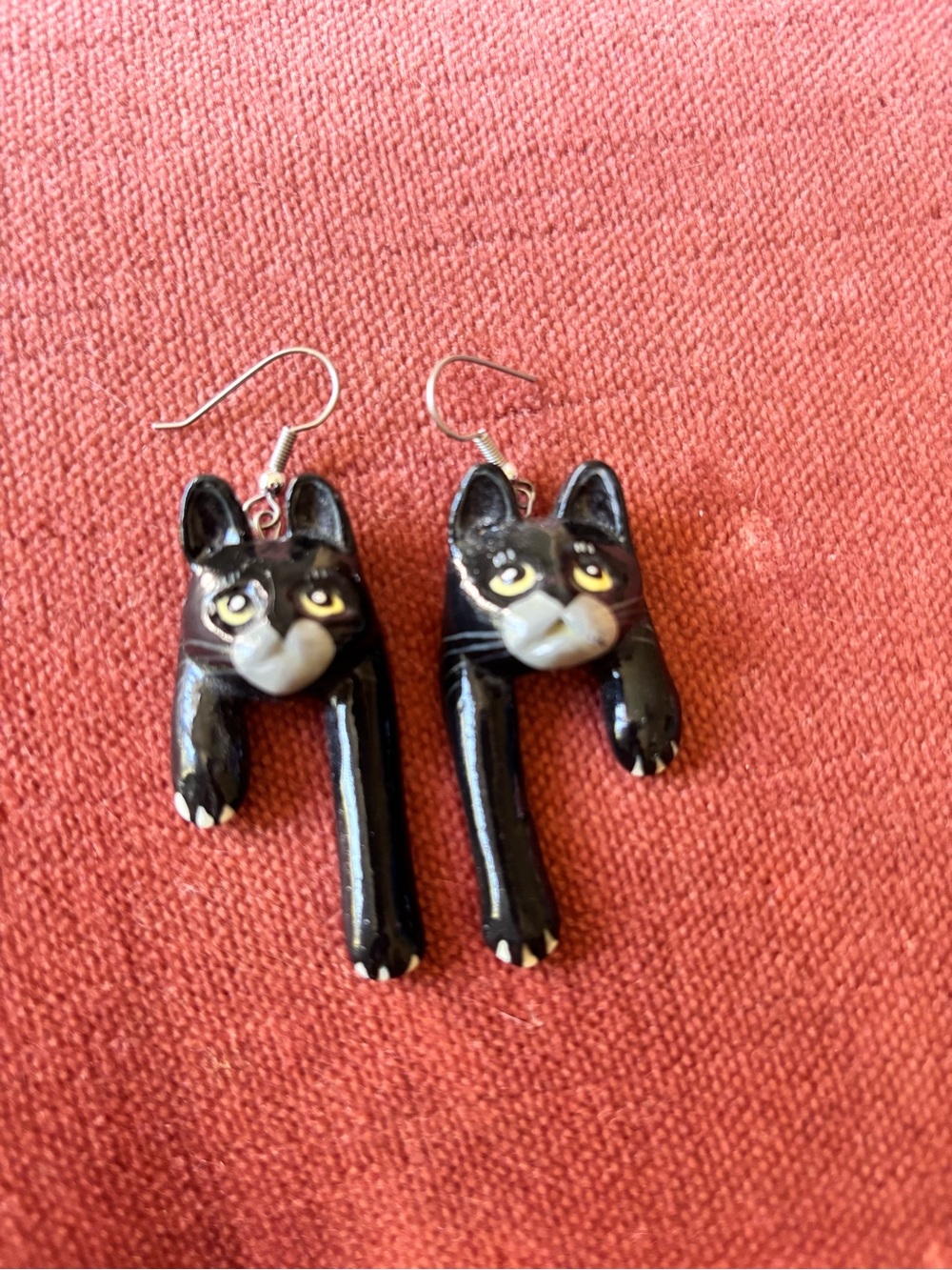 Charming vintage-style dangle earrings feature elongated black cat bodies